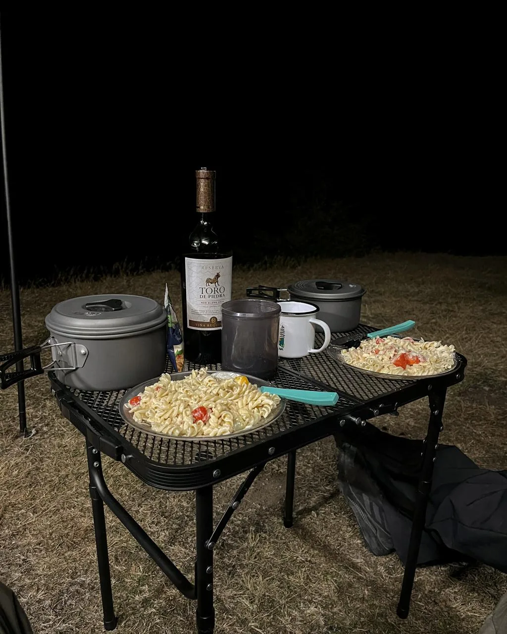 Cena de pasta y vino junto al camper, de noche
