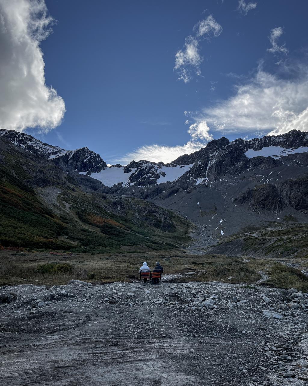 Viajeros contemplando la cordillera desde sus sillas de camping