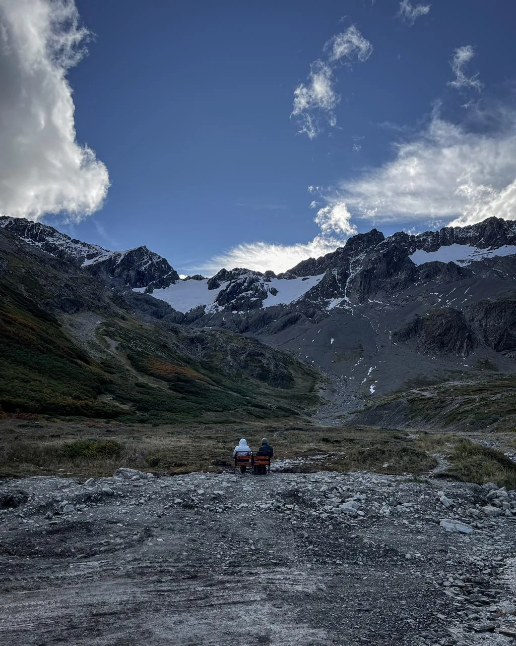 Viajeros contemplando la cordillera desde sus sillas de camping