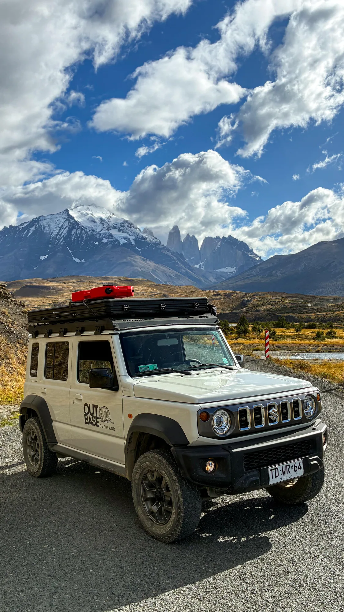 Camper Outbase frente a las Torres del Paine bajo un cielo dramático